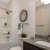 a bathroom with a marble countertop large mirror and tub