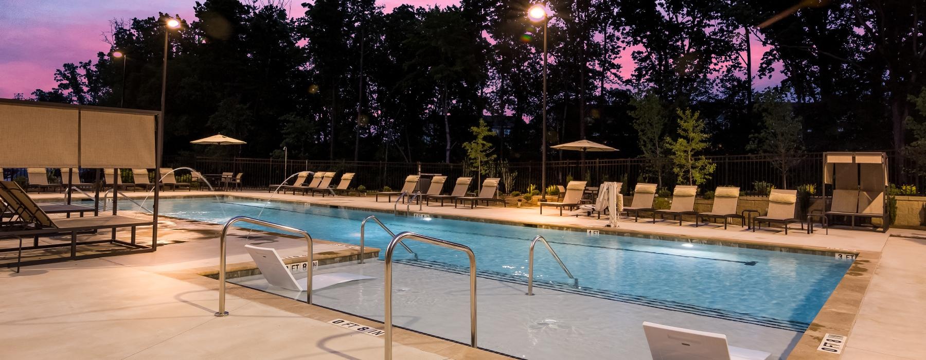 a swimming pool with a deck and chairs around it